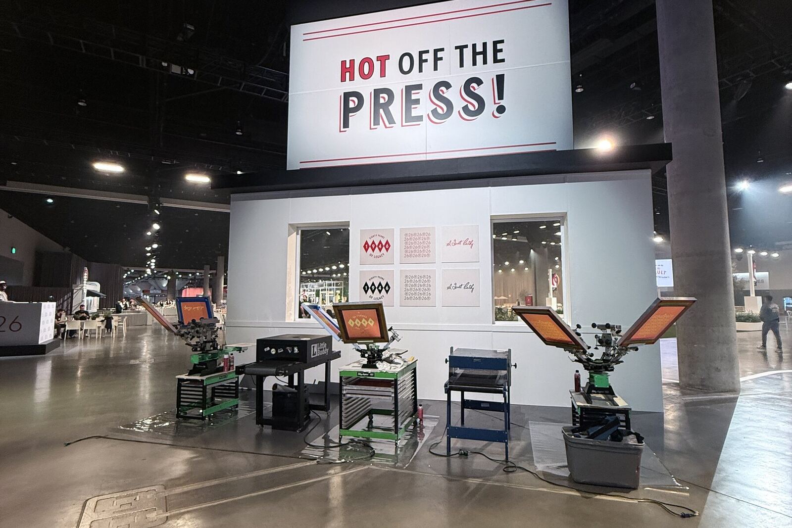 Screen printing station with 'Hot Off The Press' branded backdrop